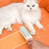 A white long-haired cat is lying on an orange surface next to a light green pet hair remover roller brush.