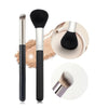 A set of professional makeup brushes including a large foundation brush, a powder brush, and a small blending brush.