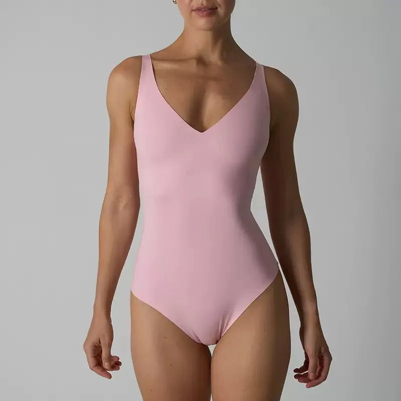 En modell iført en sømløs rosa magekontroll-body med thong.