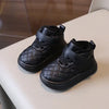 A pair of black baby winter snow boots with a quilted texture and soft sole resting on a light surface.