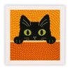 Un gato negro bordado con hilo naranja sobre un fondo texturizado.