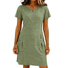 A woman wearing an olive green lightweight cotton-linen short sleeve dress with a zippered collar and front pockets.