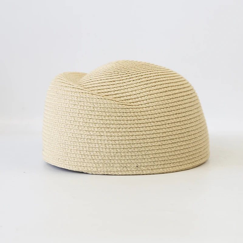 A beige straw pillbox sun hat with a wide brim shown against a white background.