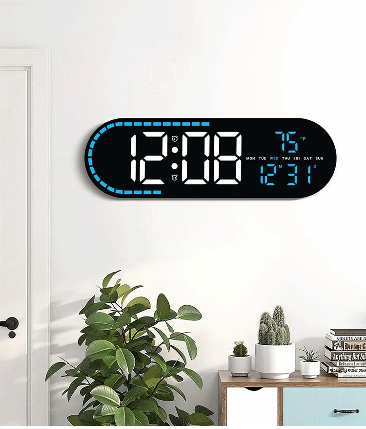 A large digital wall clock displaying time, temperature, and day of the week on a white wall.