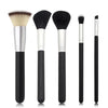 A set of professional makeup brushes including foundation, concealer, and blush application tools.