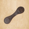 A dark brown PU leather magnetic bookmark with a double-sided clip resting on a light beige textured background.