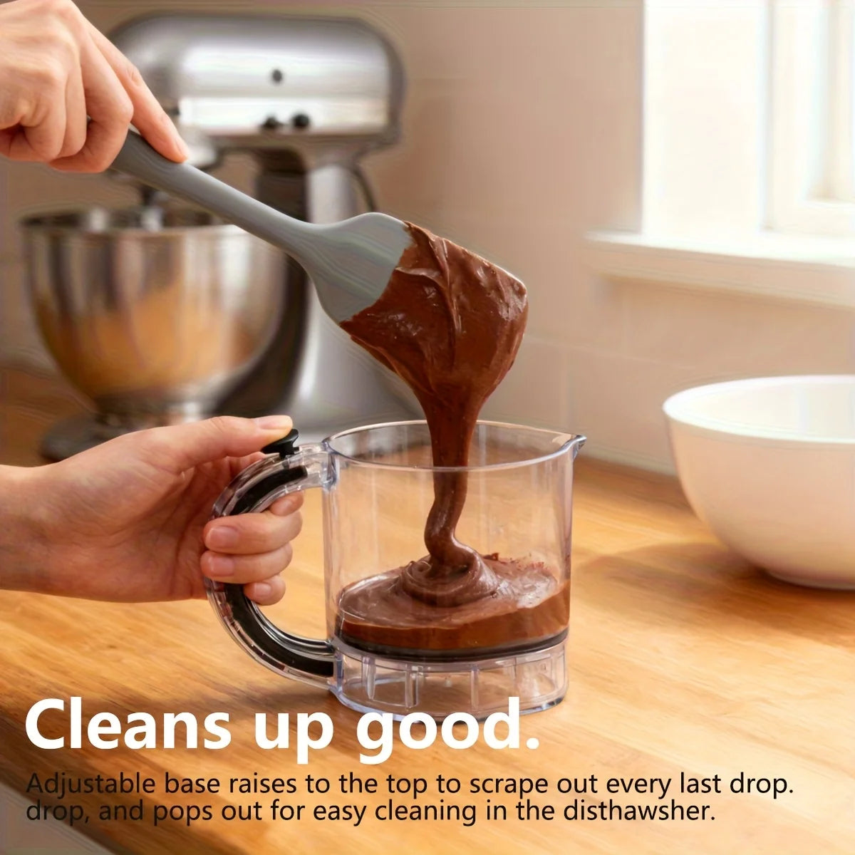 Hands pour dark brown paste from a silicone tool into a glass measuring cup for easy dishwashing.