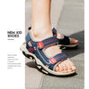 A close-up of new kid shoes, blue and red sport sandals with adjustable straps, worn on a foot.
