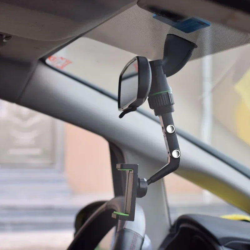 A black phone mount is installed on a car windshield, designed for 360° rotation and multi-position use.
