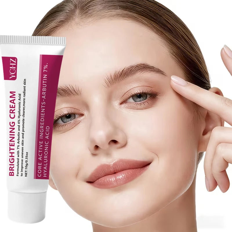 A woman applies brightening cream to her face, showing the product tube and smooth skin.