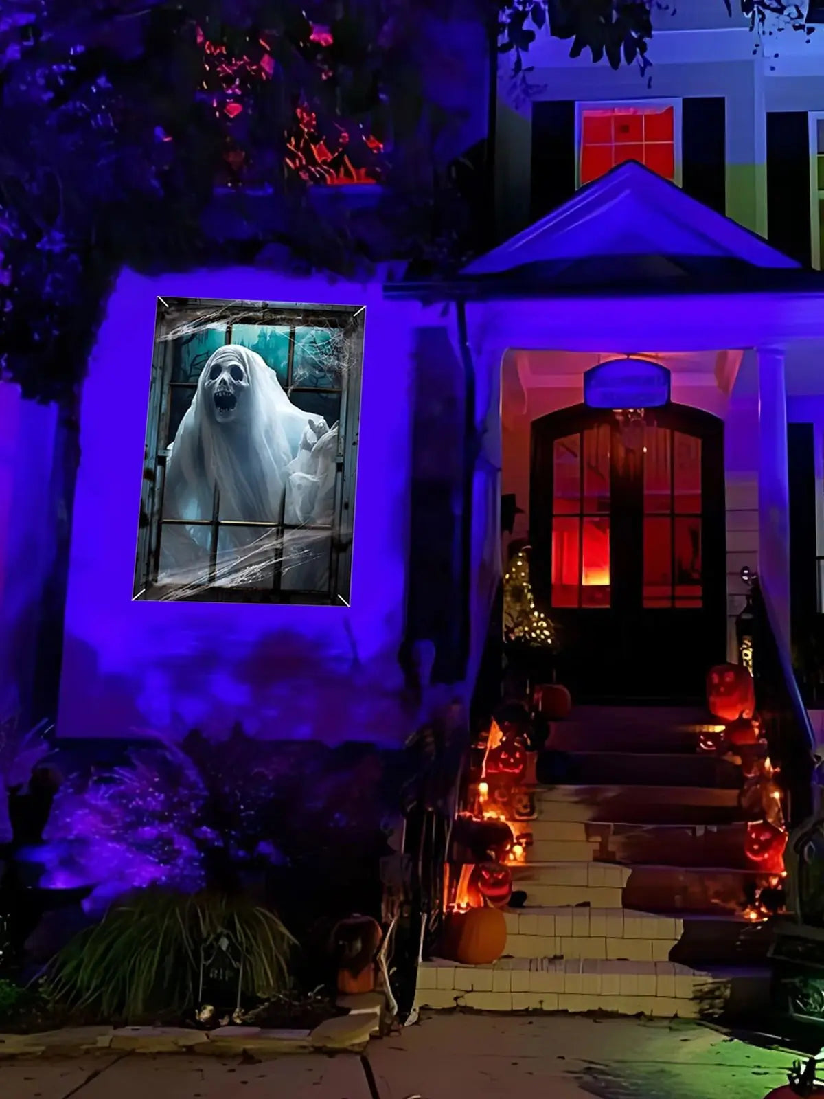A haunted house facade featuring a window cling of a ghostly figure and an entrance with glowing orange decorations.