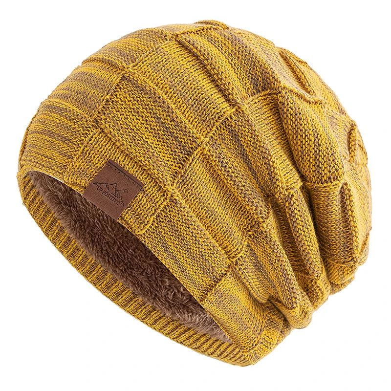 A yellow knit beanie with a brown faux fur trim and a leather patch detail.