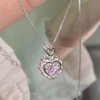 Silver heart pendant necklace featuring a purple gemstone surrounded by small diamonds and angel wings.