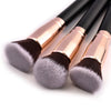 A set of professional makeup brushes with pink metal ferrules and dark gray bristles.
