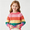 A young girl models a pink, orange, and yellow rainbow striped knit sweater with long sleeves.