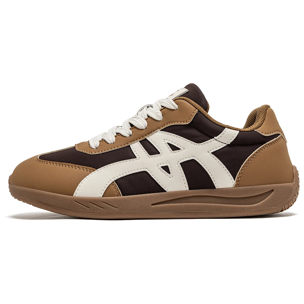 Minimalistischer Sneaker in Braun und Schwarz mit weißen Schnürsenkeln und breiter Zehenbox, seitlich abgebildet.
