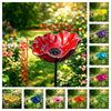 A vibrant red handcrafted metal flower garden stake shaped like a bowl, displayed in a lush green garden.