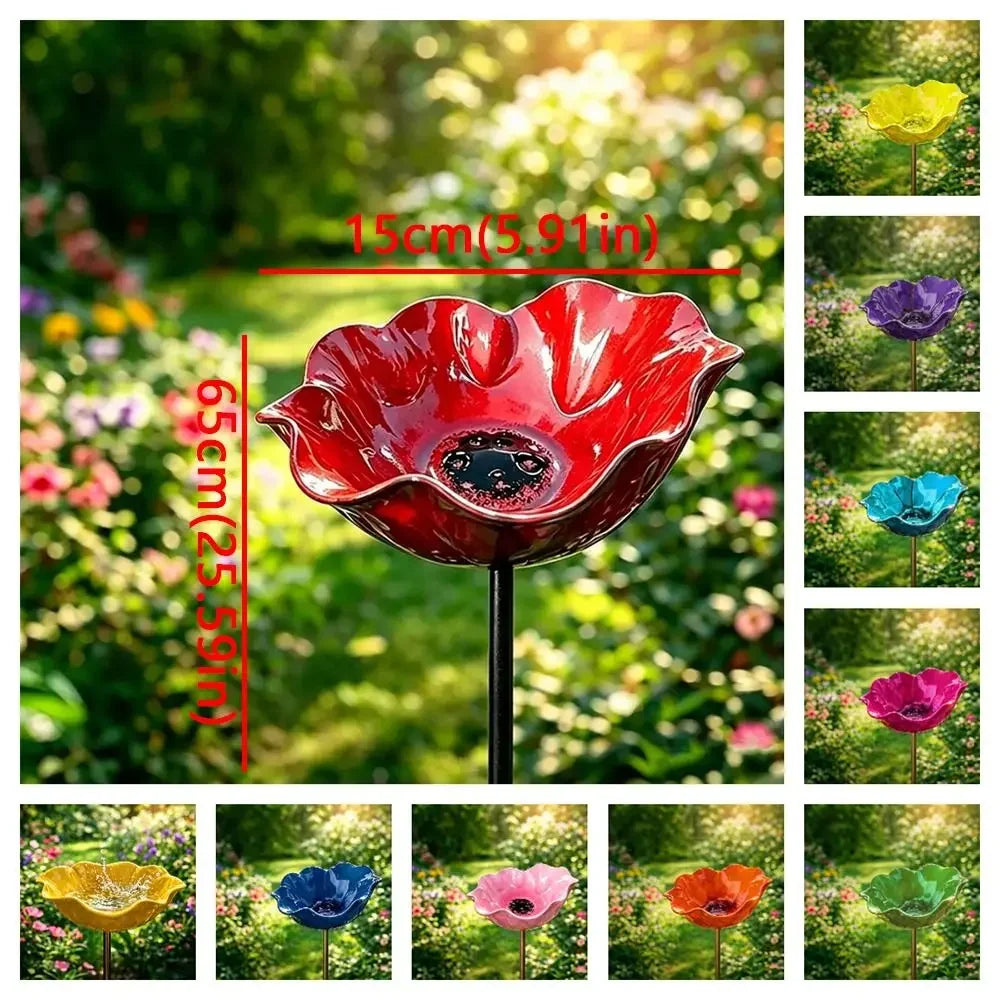 A vibrant red handcrafted metal flower garden stake shaped like a bowl, displayed in a lush green garden.