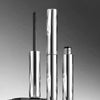 A silver waterproof volumizing mascara and defining brush standing vertically against a gray background.