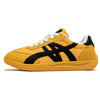 Ein gelber und schwarzer Sneaker mit weißen Schnürsenkeln und breitem Zehenbereich, von der Seite gezeigt.