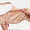 A hand is holding a beige breathable mesh under-cup bra, highlighting its stretchy and sweat-free comfort.