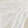 White cotton dress with eyelet lace detailing and ruffled tiers for a toddler girl