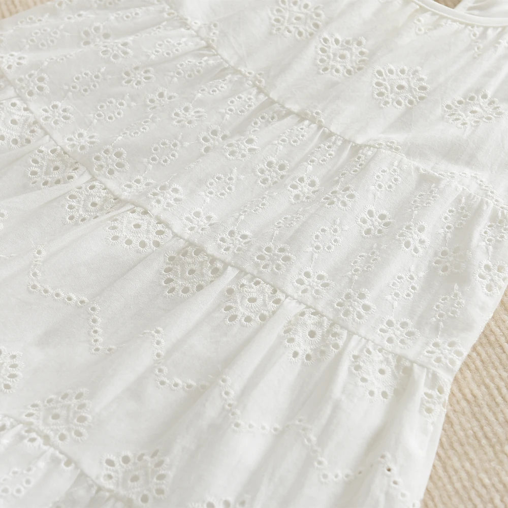 White cotton dress with eyelet lace detailing and ruffled tiers for a toddler girl