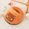 An orange bear-shaped fleece foot warmer with pink details resting on a white surface.