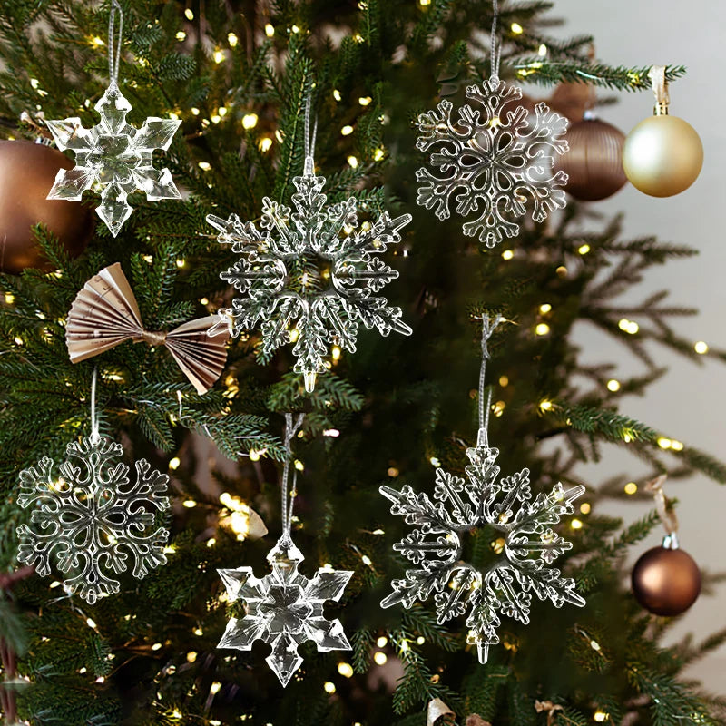 Nærbilde av juletre pyntet med tre gjennomsiktige akryl-snøfnugg-ornamenter