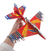 A hand holds an LED foam glider airplane toy with red and blue accents against a white background.