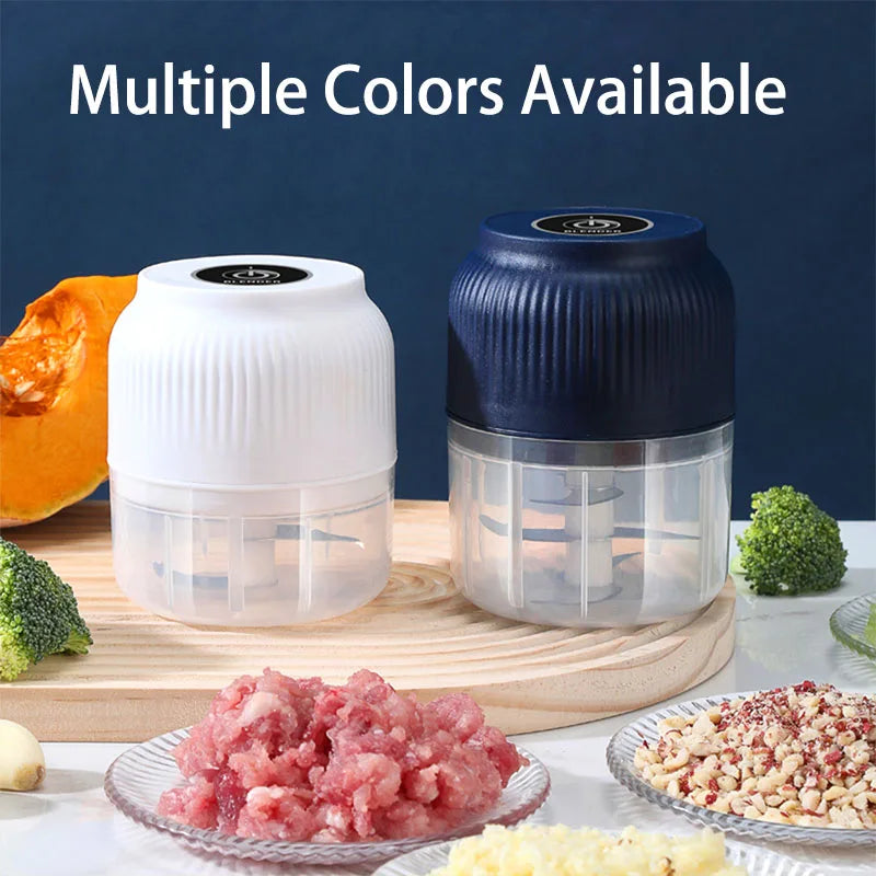 A white and blue mini USB rechargeable electric food chopper is shown with chopped herbs and garlic on a wooden cutting board