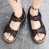 A pair of brown men's genuine leather air cushion sandals worn on a person's feet.