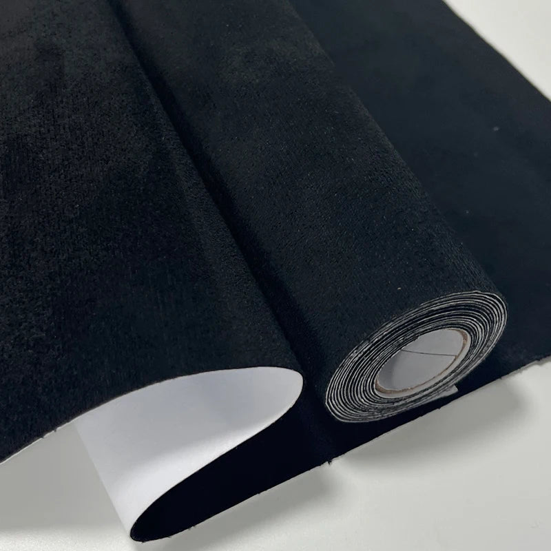 Roll de tela de gamuza negra con acabado aterciopelado, mostrando el borde enrollado.