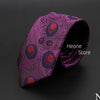 Corbata jacquard púrpura con diseño estampado de acentos rojos y azules, enrollada.