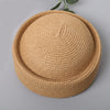 A round straw sun hat with a wide brim in a natural beige color.