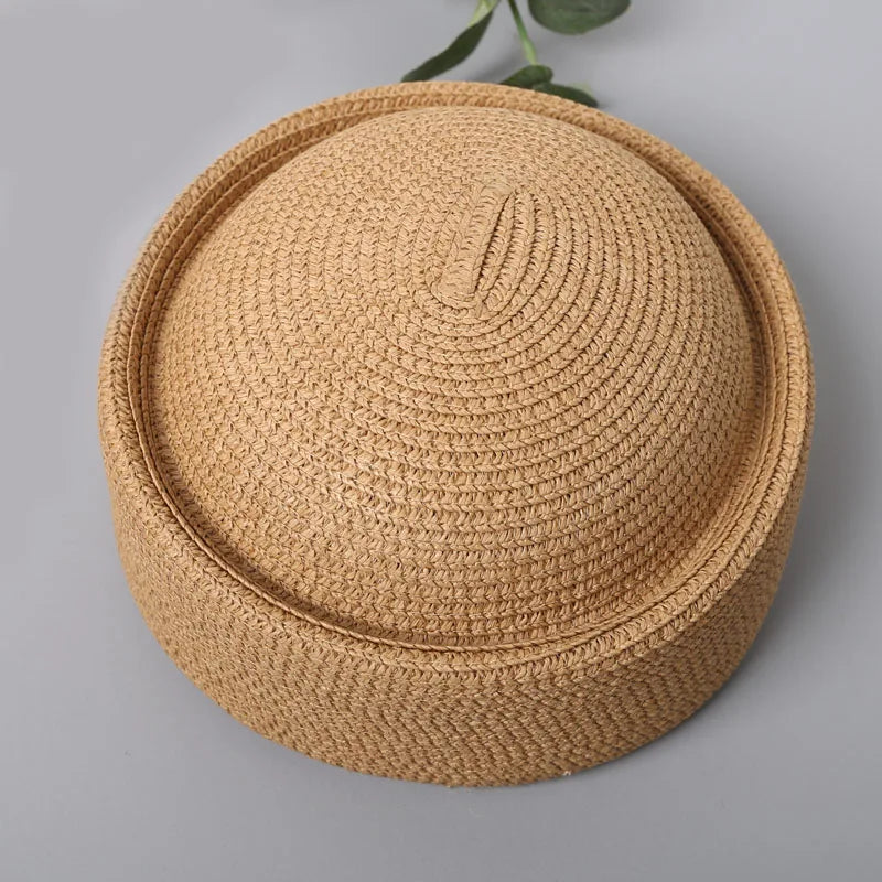 A round straw sun hat with a wide brim in a natural beige color.