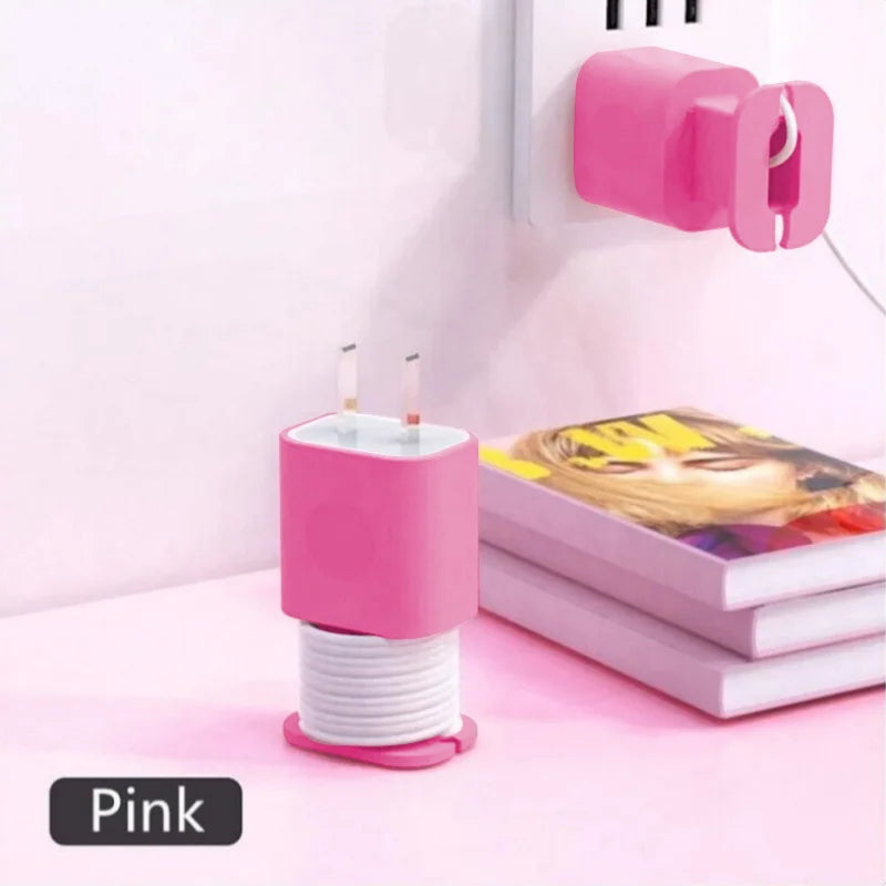 Pink silicone charger protector and cable organizer with a pink plug mounted on a white wall.