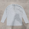 A light gray men's casual long-sleeve shirt with a collar and chest pocket lying flat on a textured surface.