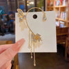 Gold butterfly zircon ear cuff with dangling gold tassels displayed on a white card.
