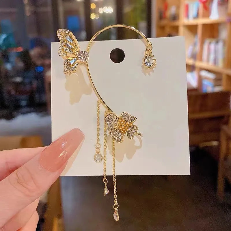 Gold butterfly zircon ear cuff with dangling gold tassels displayed on a white card.