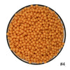 A pile of small, round, orange water beads filling a black bowl.