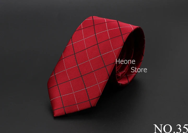 Una corbata roja a cuadros doblada y exhibida sobre una superficie oscura.