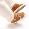 A pair of tan suede baby winter snow boots with white fuzzy trim and white socks.