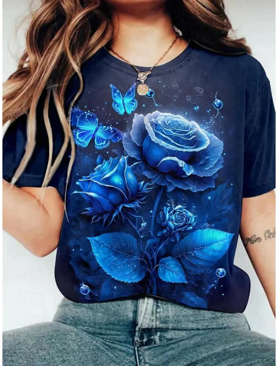 A dark blue t-shirt featuring a vibrant floral print of blue roses and butterflies.