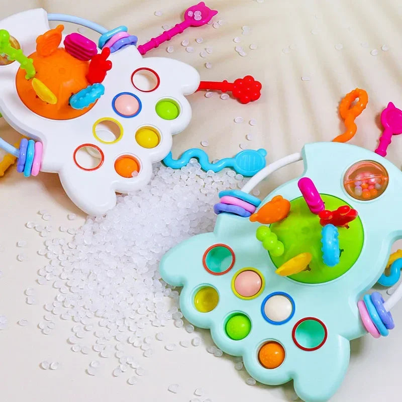 A white sensory pull string teething toy with colorful plastic parts and holes is shown next to a light blue version.