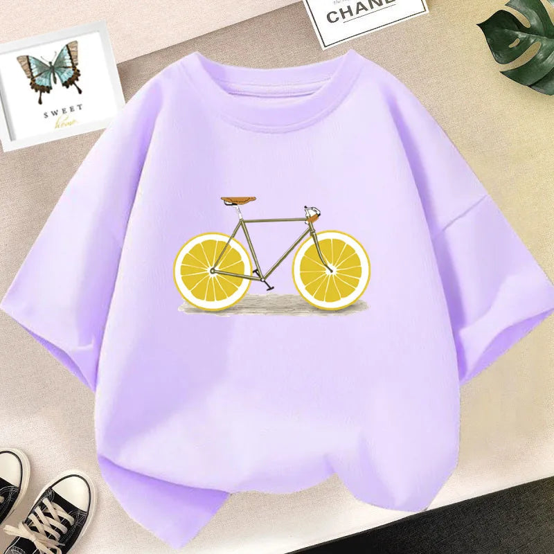 Light purple kids t-shirt featuring a graphic design of a bicycle with orange slices.