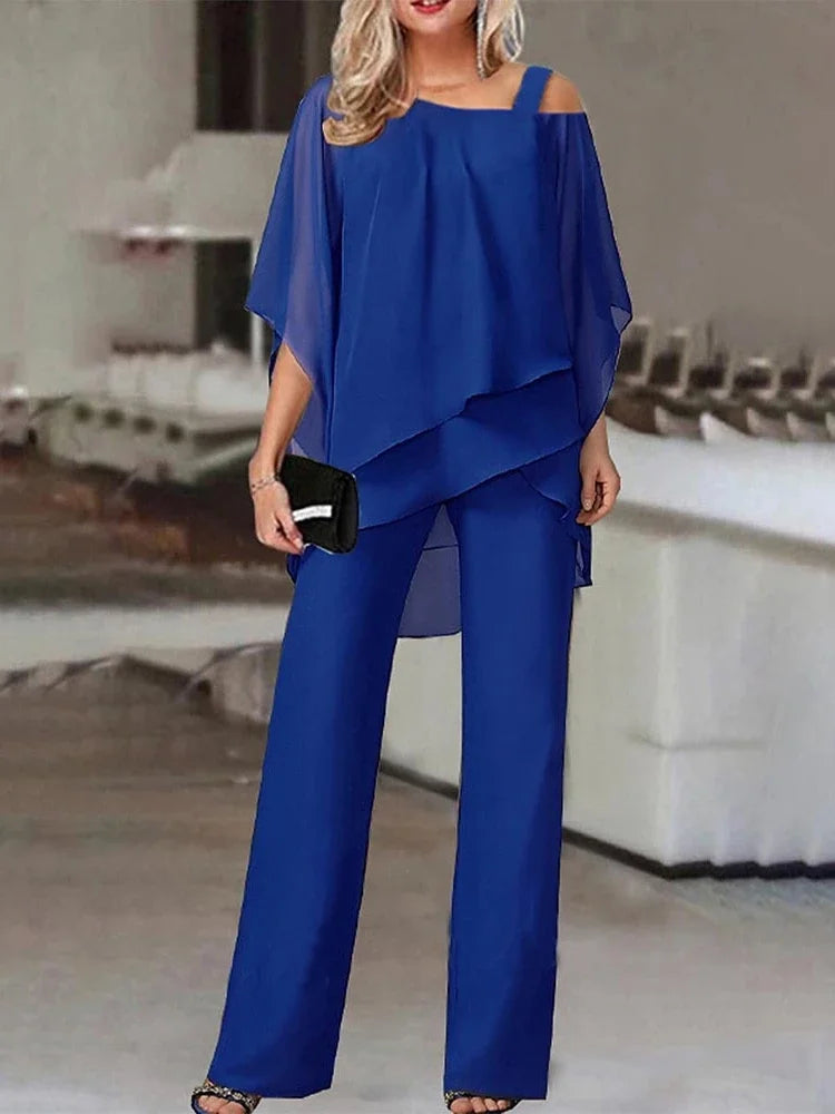 En kvinne modellerer et kongeblått top-og-bukse-sett med off-shoulder topp og vide bukseben.