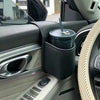 Interior view of a car showing a door storage organizer with a cup holder and phone pocket on the dashboard.