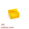 A single yellow marble run building block piece with tracks and funnels.