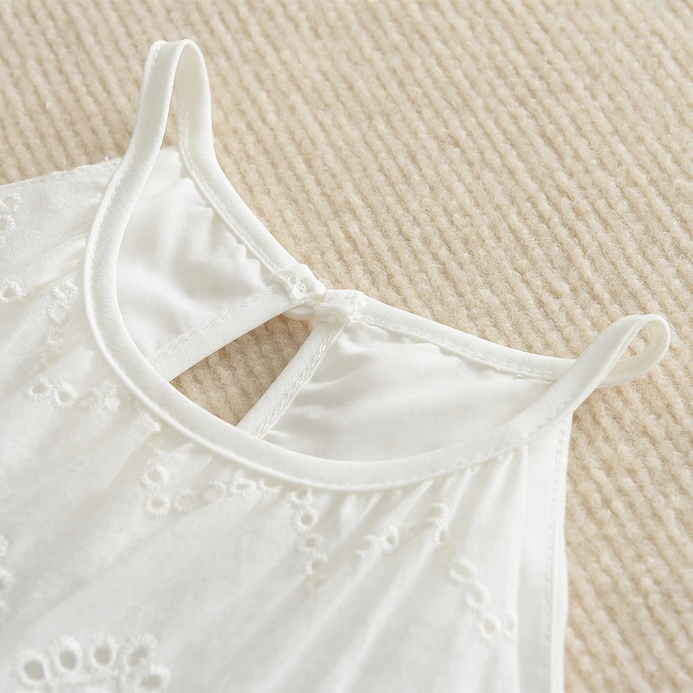 White cotton suspenders dress for a toddler girl shown from the front